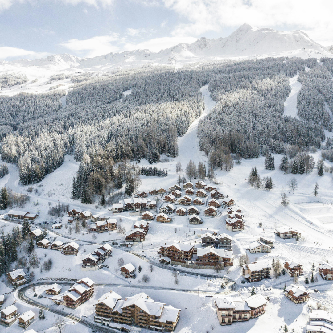 Snow covered chalets on a mountain.